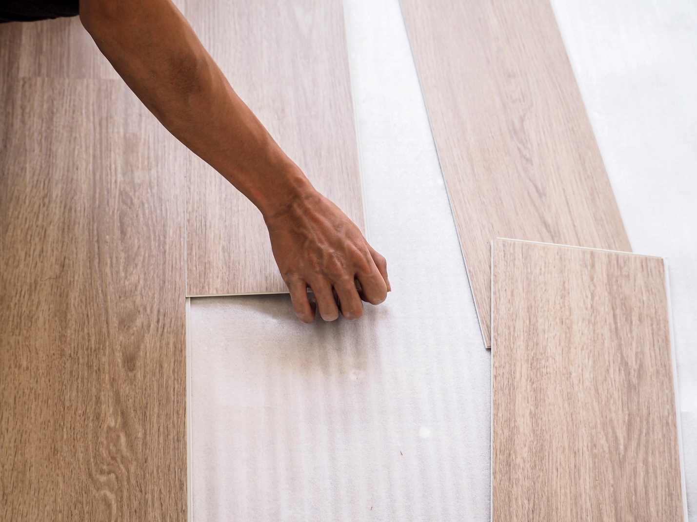 A remodeler installing a wood floor